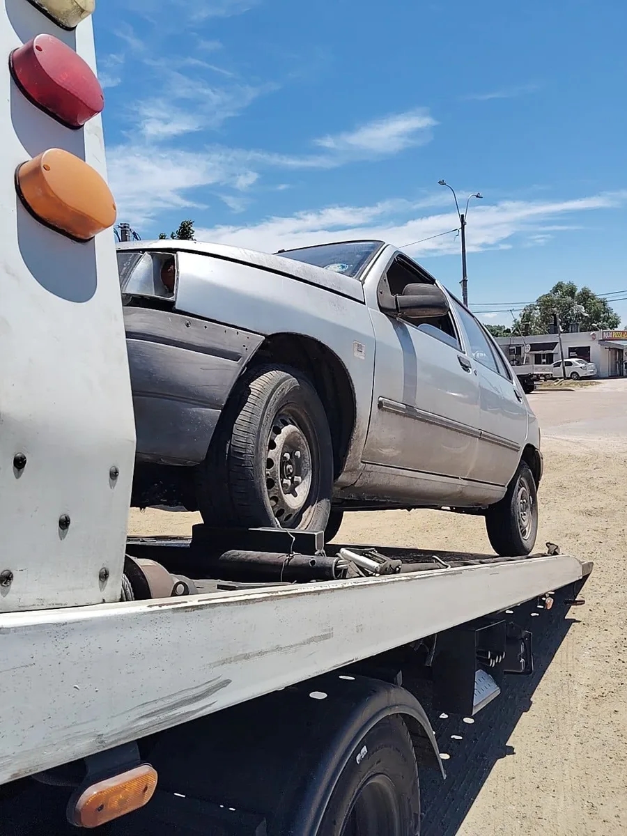 Traslado de un hatchback plateado sobre plataforma