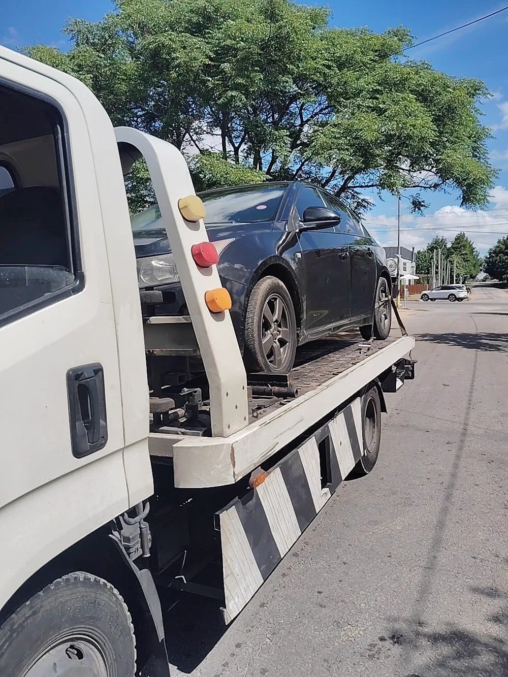Traslado de un sedán negro en una calle residencial