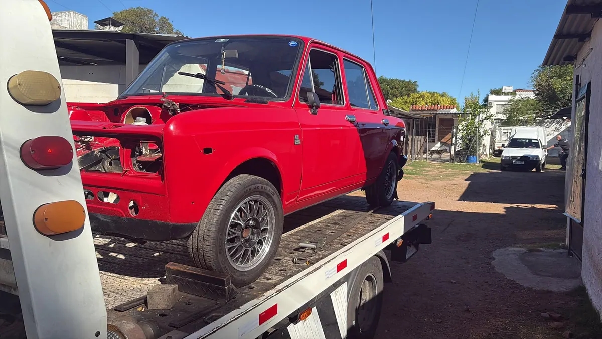 Traslado de un auto clásico rojo sobre plataforma